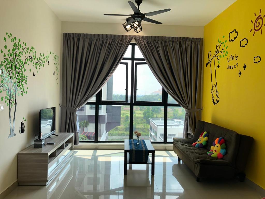 a living room with a couch and a large window at i-Walker @ IOI Conezion Putrajaya in Putrajaya