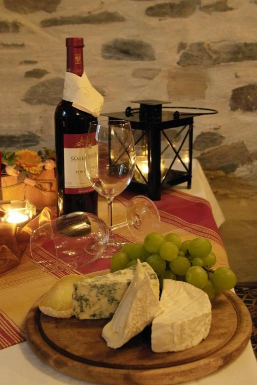 a plate of cheese and grapes and a bottle of wine at Hotel Zur Fernmühle in Ziegenrück