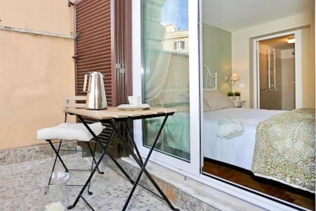 ローマにあるサン ヴィート スイーツのデスク、ベッド、窓が備わる客室です。