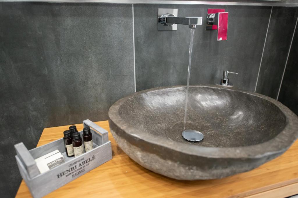 a bathroom with a large stone sink on a counter at Hermes rooms for tourists in Naples
