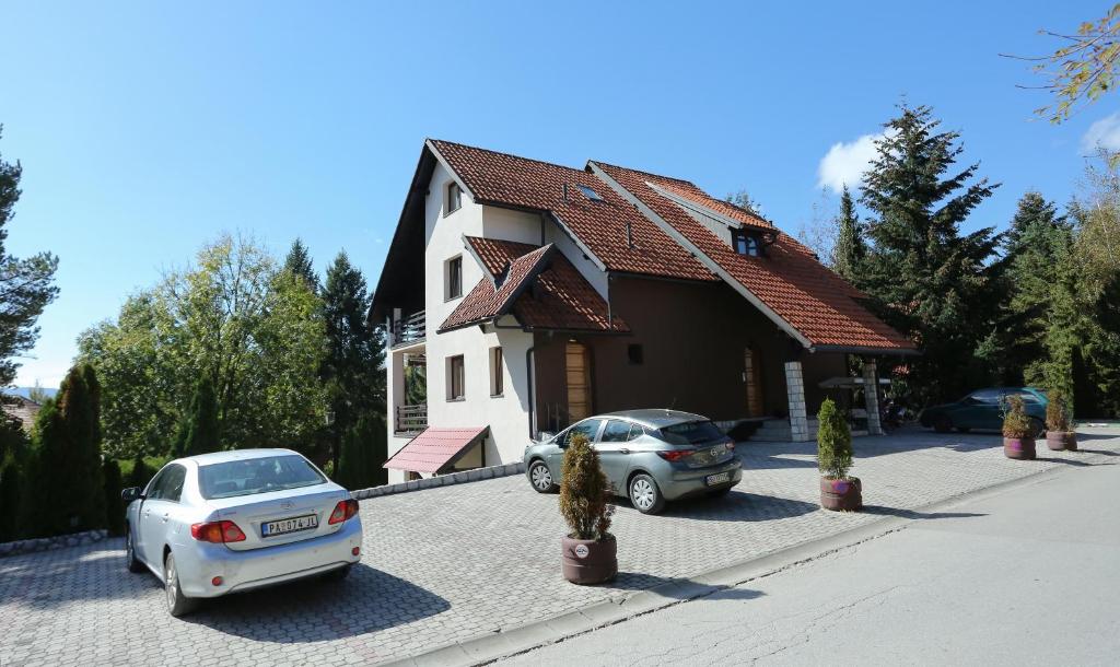 dois carros estacionados em frente a uma casa em Apartments Vila Knez em Zlatibor