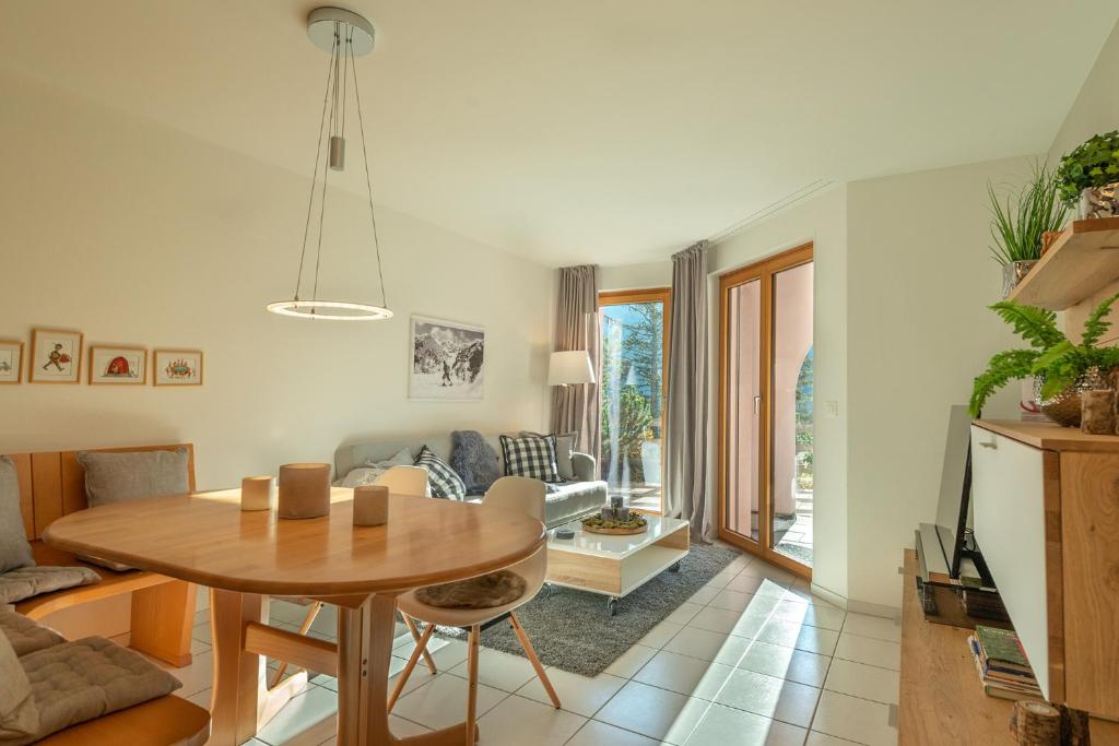 uma sala de estar com uma mesa e um sofá em Haus Belvédère em Arosa