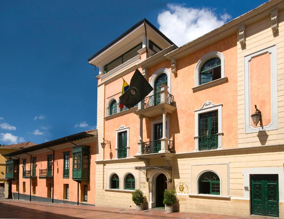 ein großes Backsteingebäude mit Balkon und Flaggen darauf in der Unterkunft Hotel De La Opera in Bogotá