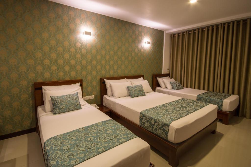 Postel nebo postele na pokoji v ubytování Ceyloni City Hotel