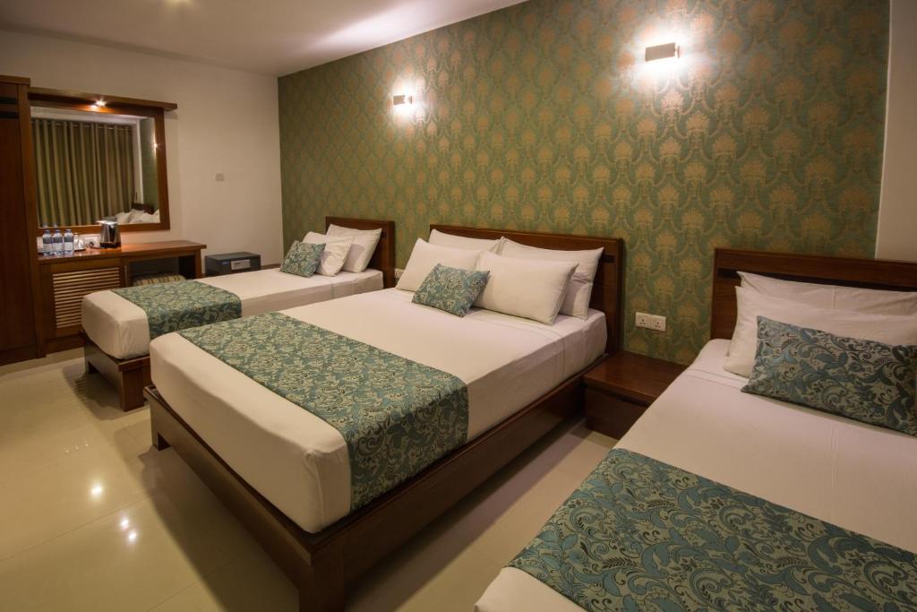 Postel nebo postele na pokoji v ubytování Ceyloni City Hotel