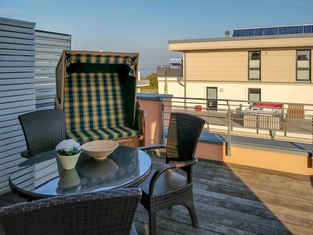 a patio with a table and chairs on a balcony at Villa Seeadler in Börgerende-Rethwisch