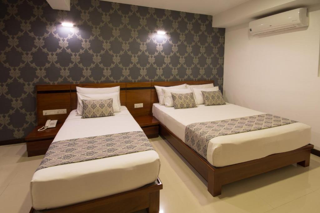 Postel nebo postele na pokoji v ubytování Ceyloni City Hotel