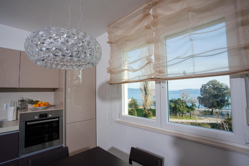cocina con ventana grande y lámpara de araña en Luxury Vesna Apartments, en Kaštela
