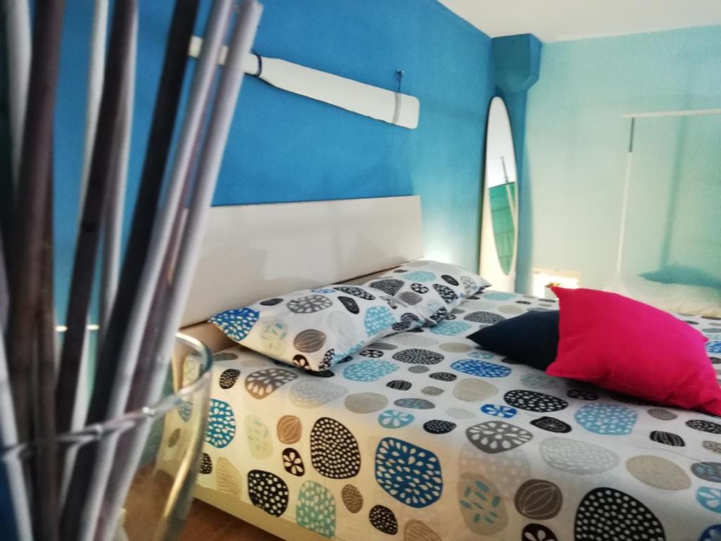 una camera da letto con un letto con cuscini sopra di Sky Blue Dreams Holiday Home a Catania