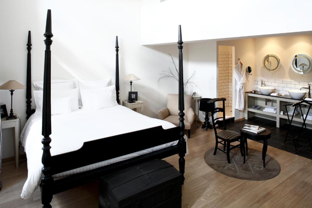 a bedroom with a black and white bed and a desk at Auberge Du Paradis in Saint-Amour-Bellevue