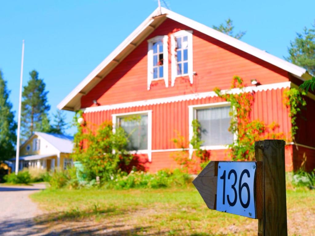 a red house with a sign in front of it at Guesthouse Miekkala in Lappeenranta