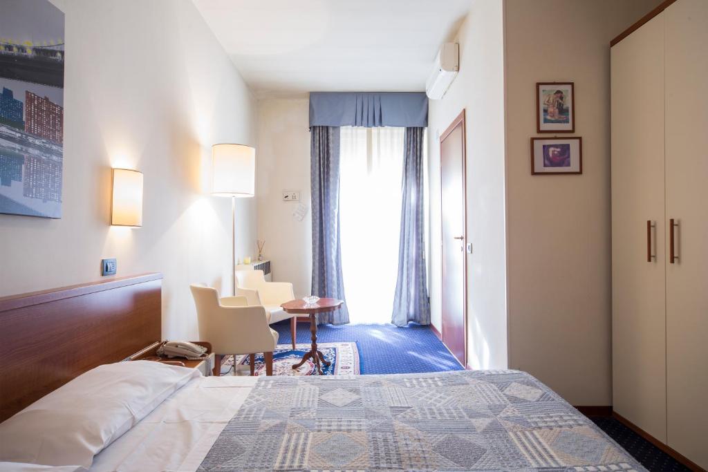 a hotel room with a bed and a table and a window at Hotel Elefante Bianco in Crespellano