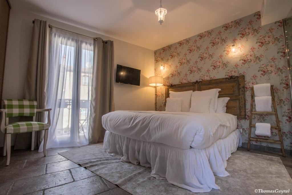 a bedroom with a large bed and a window at Demeure Terrisse La Maison in Marseillan