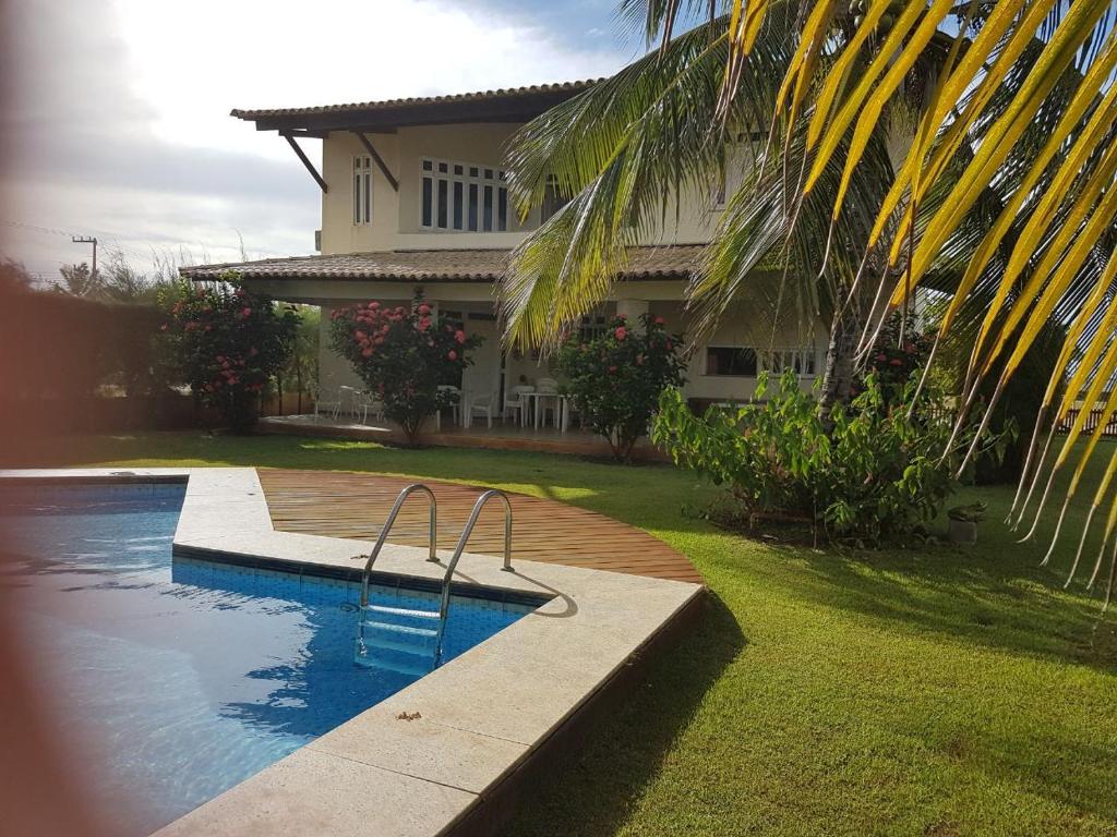 una casa con piscina frente a una casa en Maravilhosa casa de praia, en Aracaju