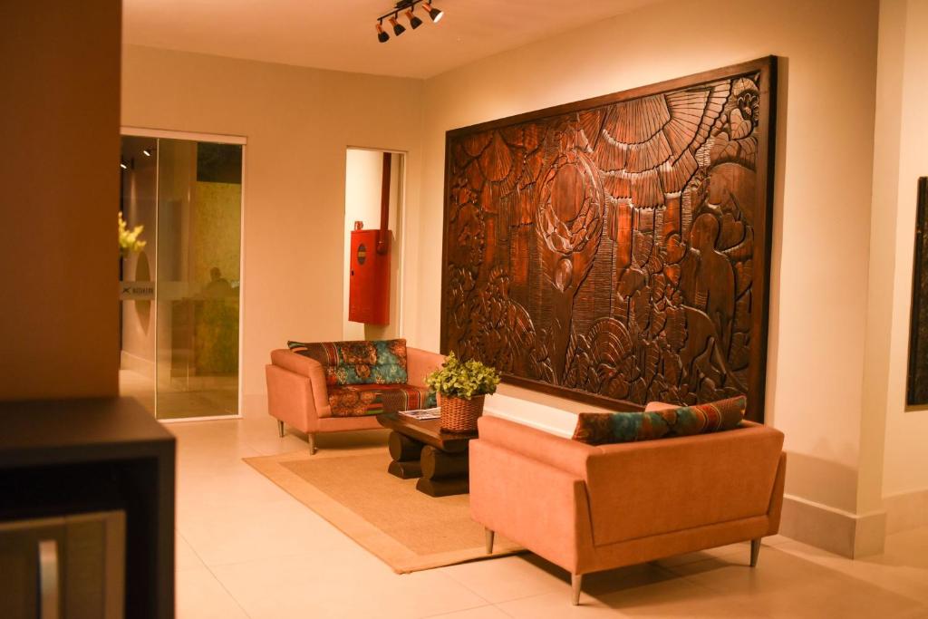 a living room with two chairs and a large wooden wall at Uiramutam Palace Hotel in Boa Vista