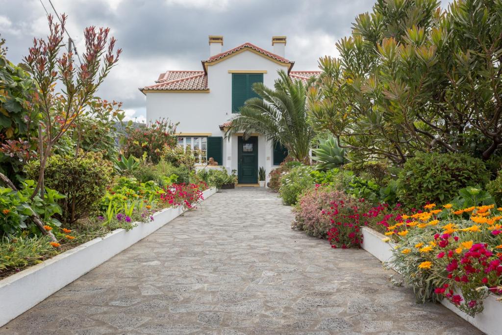 um caminho de jardim que leva a uma casa com flores em Apartamentos em Casa da Avó Inês em Porto Formoso