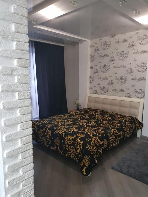 a bedroom with a bed and a brick wall at Стильные аппартаменты на Новых Домах in Kharkiv