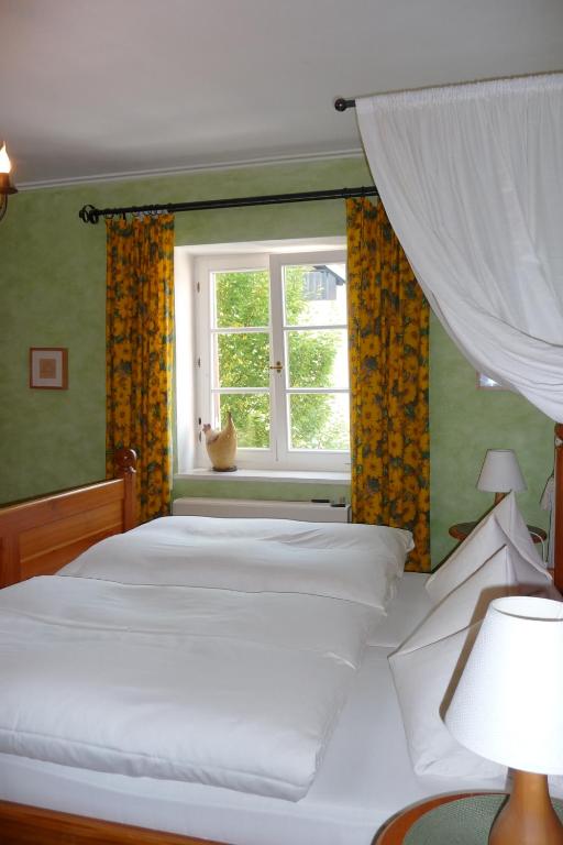 Schlafzimmer mit einem weißen Bett und einem Fenster in der Unterkunft Hotel garni Lindenhof im Steigerwald in Oberaurach