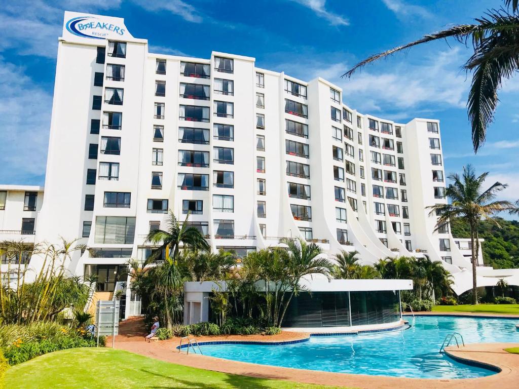 a large white building with a pool in front of it at Breakers Resort Apartments in Durban