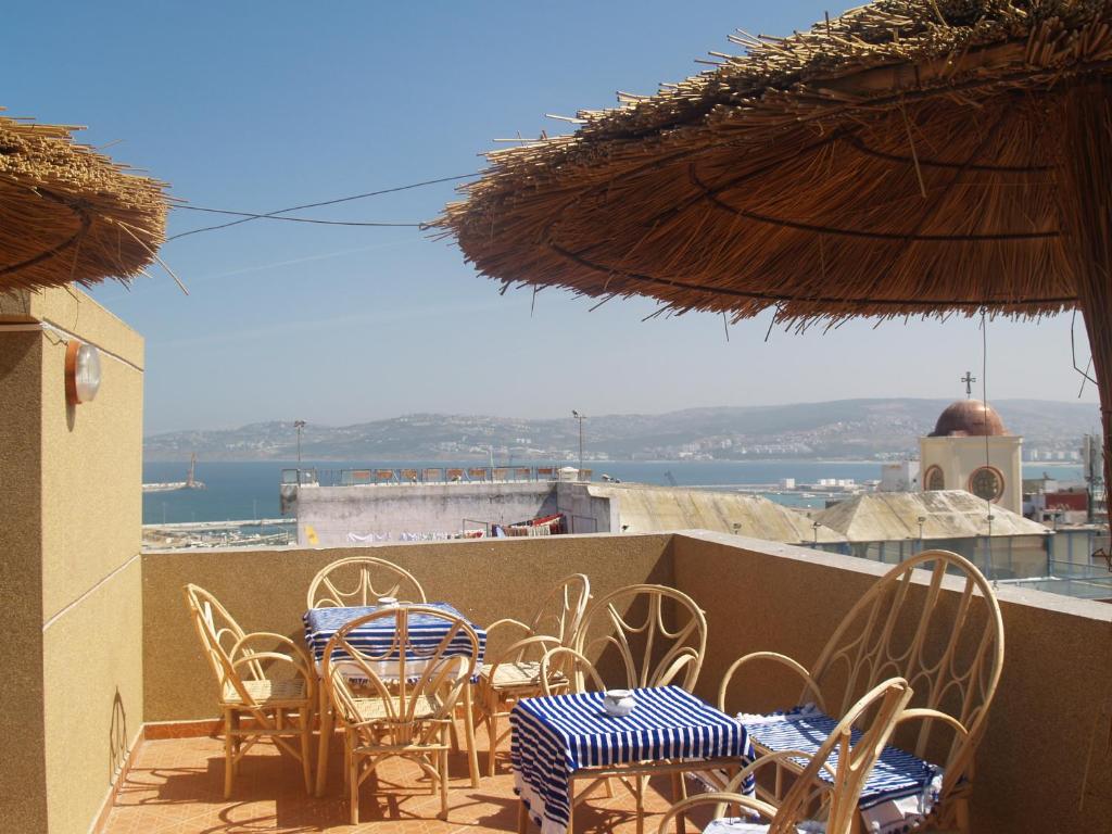 un ensemble de tables et de chaises sur un balcon dans l'établissement TanjaLucia Hostel, à Tanger