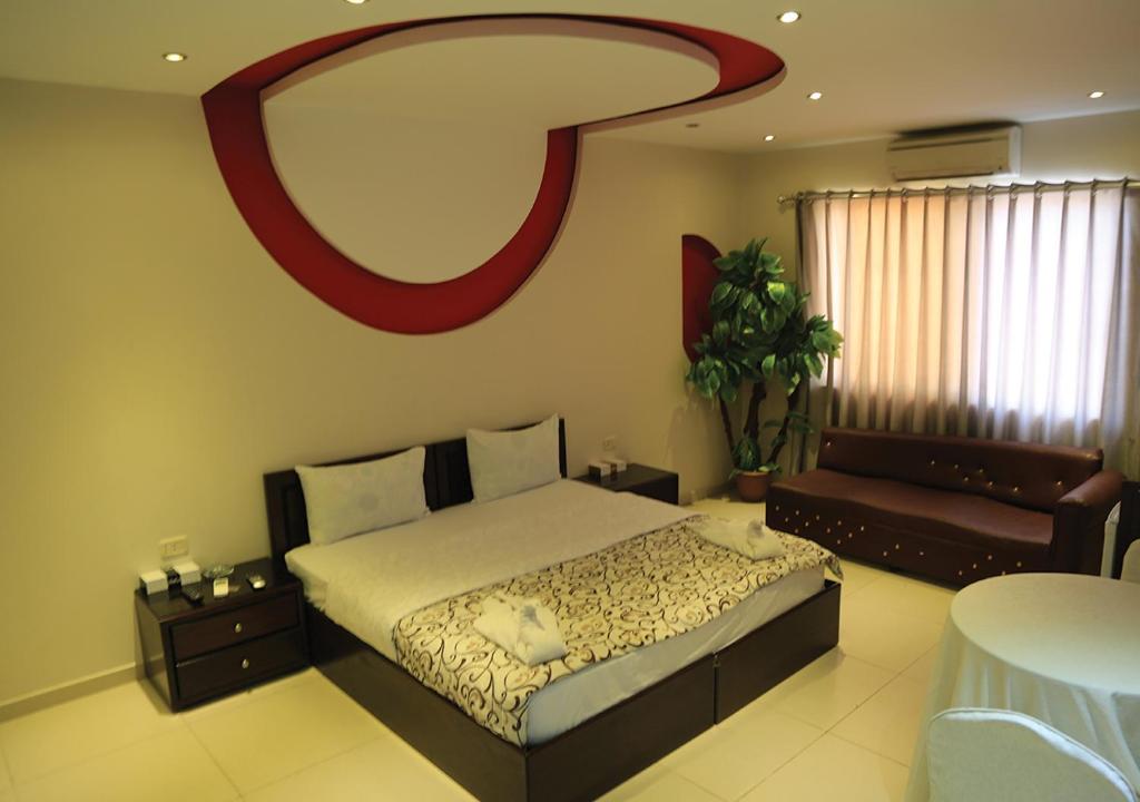 a bedroom with a bed and a mirror on the wall at Ajnadeen Hotel in Irbid