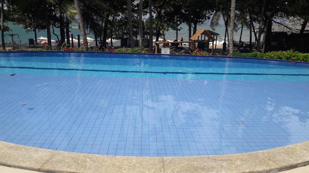
a swimming pool with a pool table and chairs at Enseada Praia do Forte Residências in Praia do Forte
