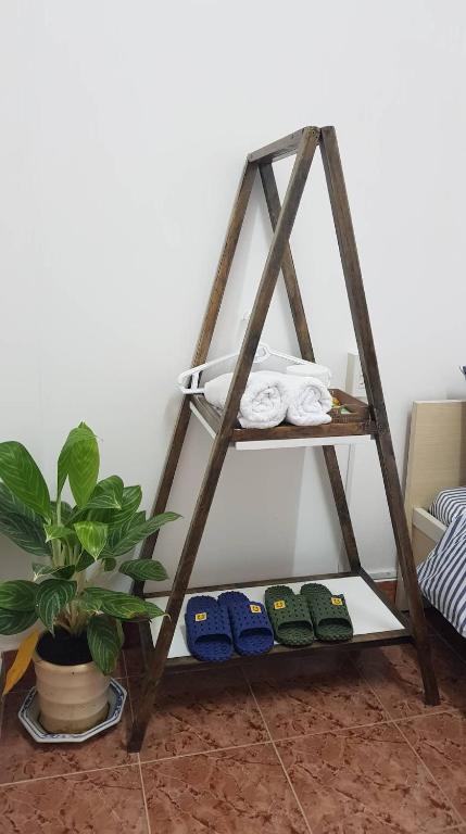 una mensola in legno con asciugamani e una pianta di Forelsket 2 a Da Lat