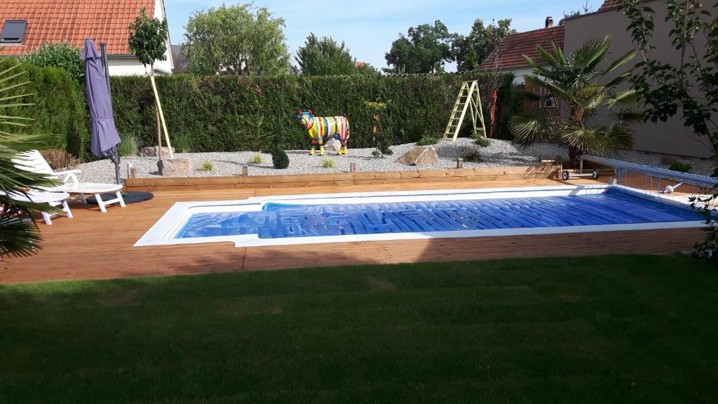 a small swimming pool in a yard with a lawn sidx sidx sidx at C' 1 comble in Bischwihr