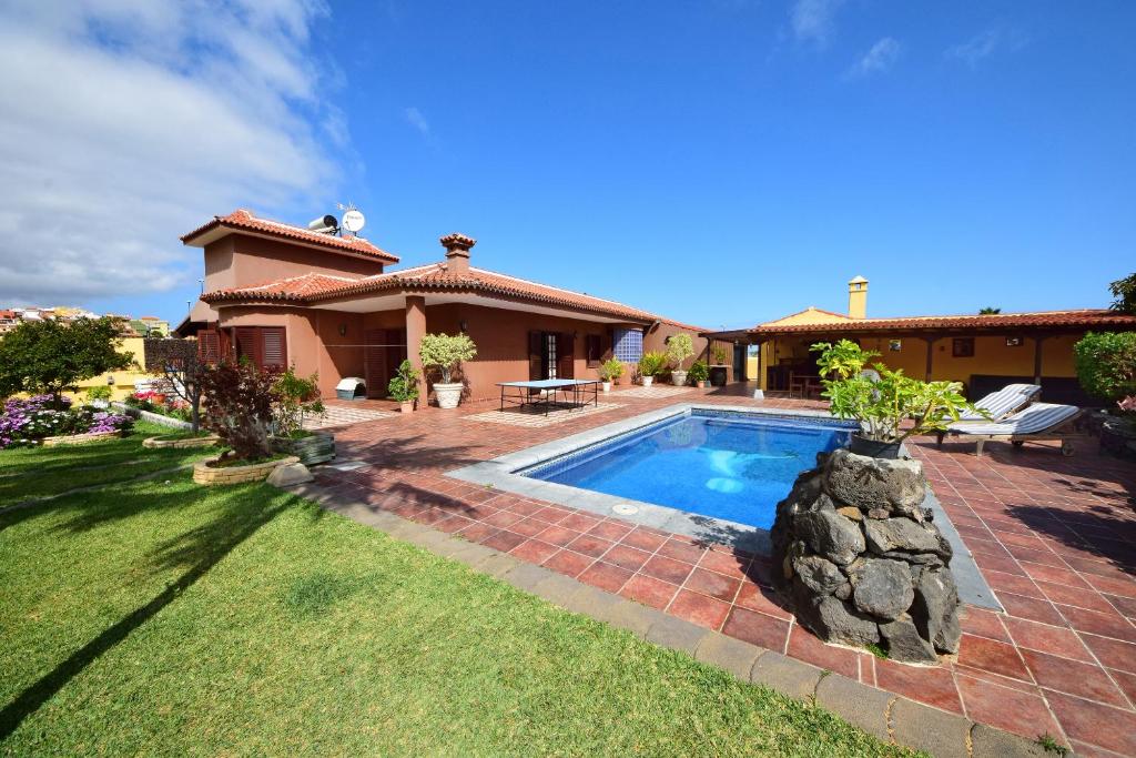 プエルト・デ・ラ・クルスにあるAlina - Vivienda vacacional con piscina privadaの庭にスイミングプールがある家