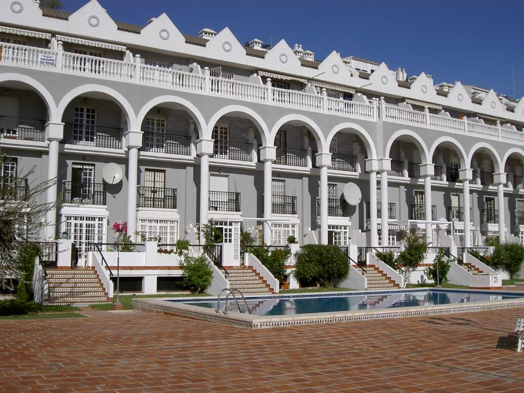 un grande edificio bianco con una piscina di fronte di Tres Carabelas a Torremolinos