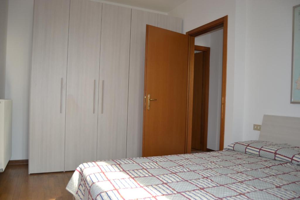 1 dormitorio con 2 camas, armarios blancos y puerta en Casa per Venezia&Treviso, en Treviso