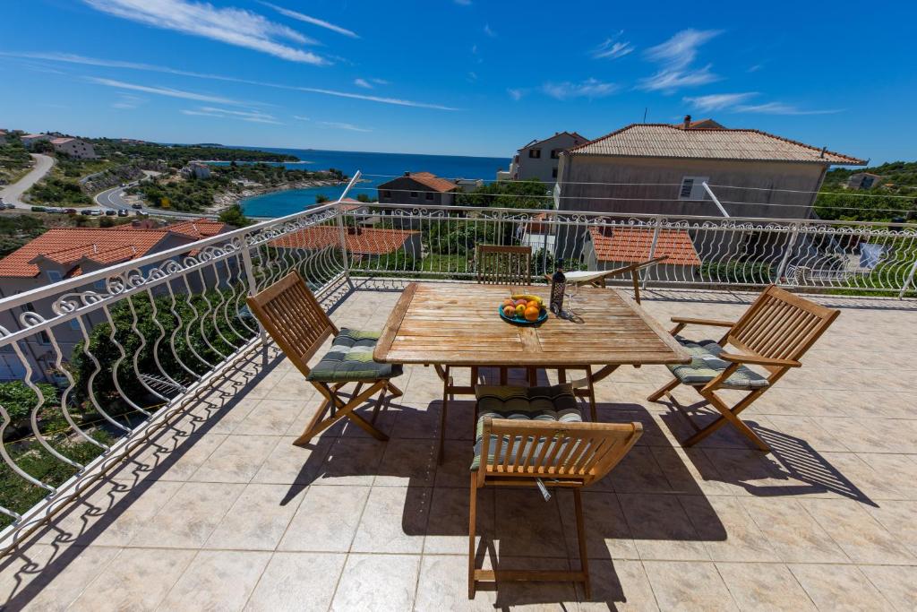 una mesa y sillas en un balcón con vistas al océano en Apartments Sunset Dolac en Primošten