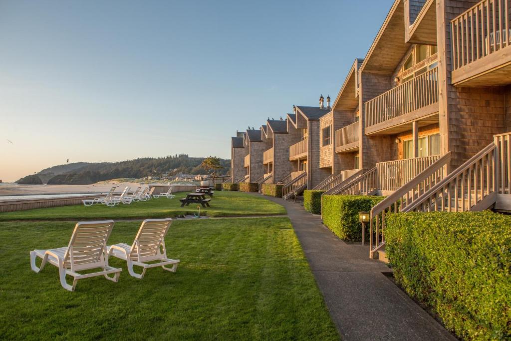 une rangée de bâtiments avec des chaises sur l'herbe dans l'établissement Schooner's Cove Inn, à Cannon Beach