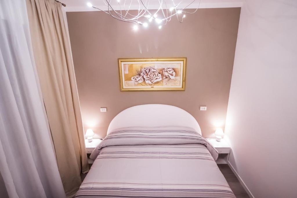 niewielka sypialnia z łóżkiem i 2 lampami w obiekcie Casa Clara w mieście Altavilla Vicentina