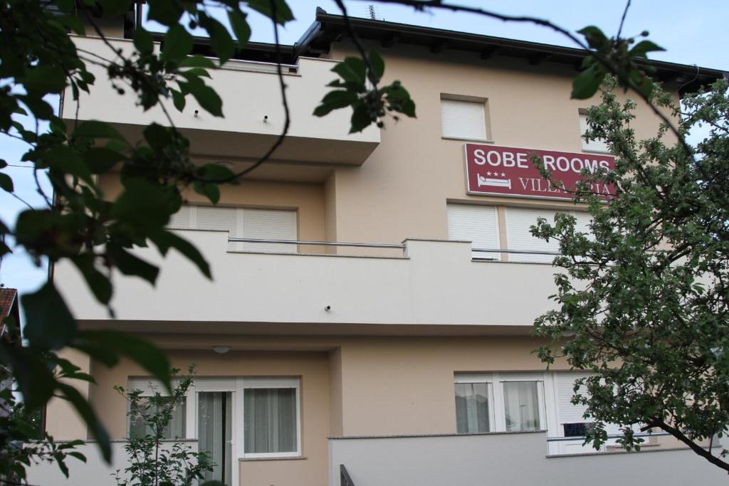 a building with a sign on the side of it at Rooms Villa Aria in Sesvete