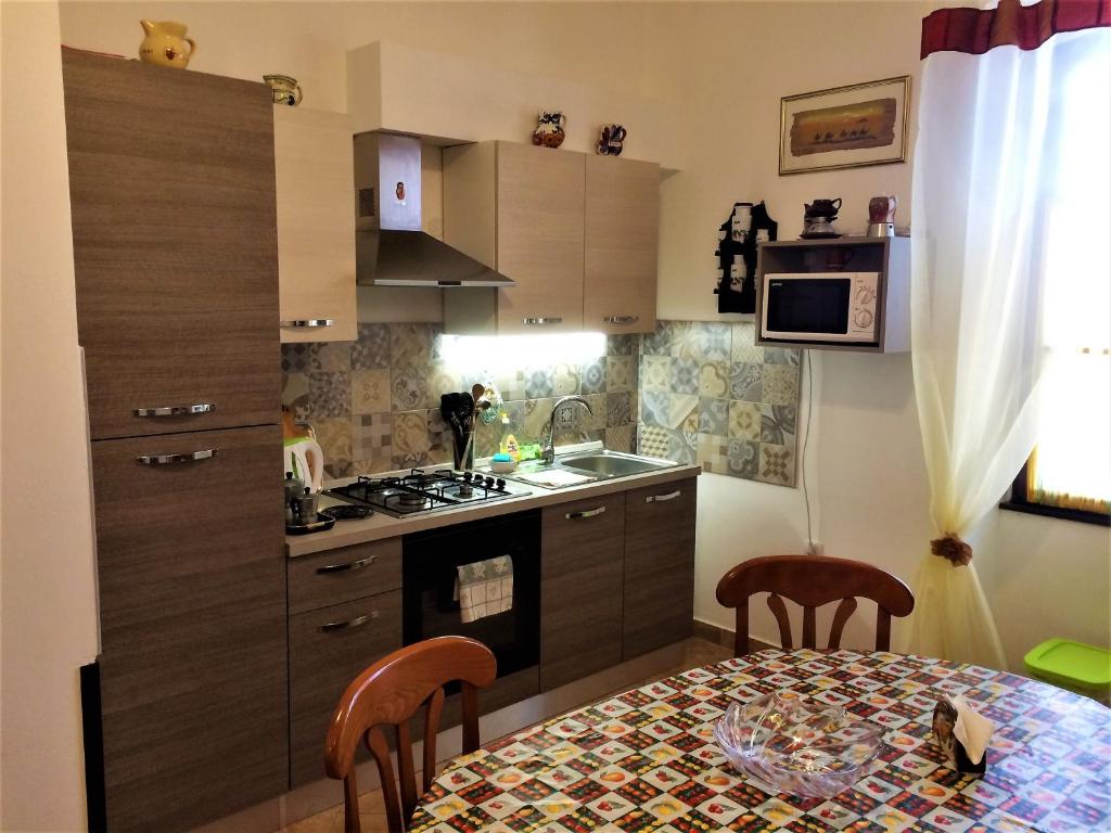 kuchnia ze stołem oraz kuchnia z kuchenką i zlewem w obiekcie Noemi City Apartments w Puli