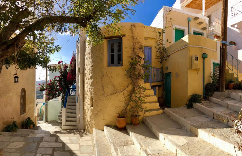 a yellow house with stairs leading up to it at Traditional Medieval Stone house in "Ano Syros" in Ano Syros