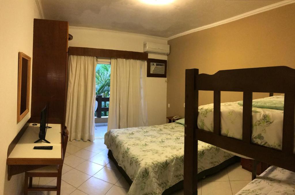 - une chambre avec des lits superposés, un bureau et un lit dans l'établissement Flat Amarilis Riviera de São Lourenço - Flat Lindo com Varanda, à Riviera de São Lourenço