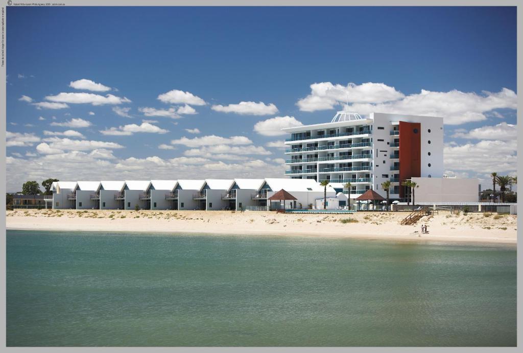 a building on a beach next to the water at Seashells Mandurah in Mandurah