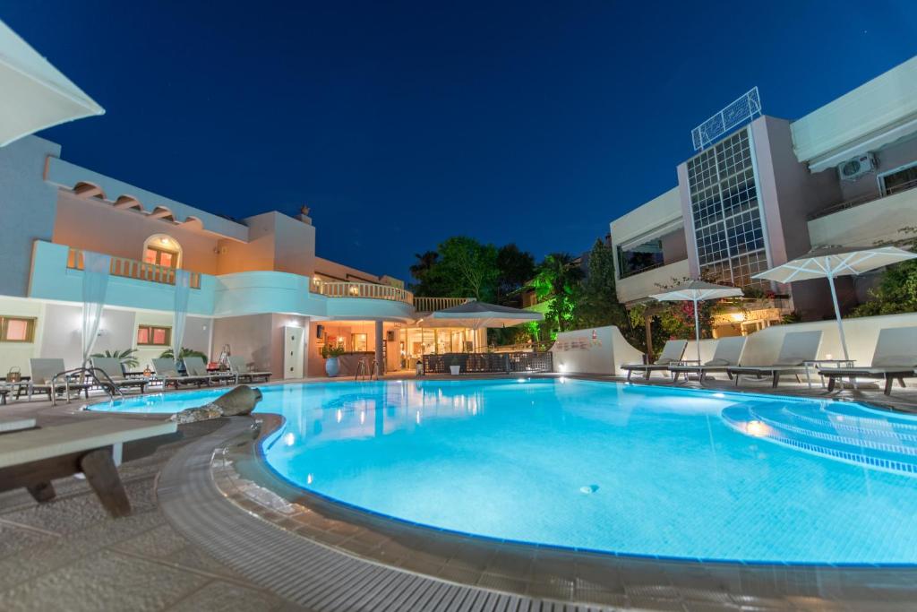 een groot zwembad in een hotel 's nachts bij Sun Rise Hotel Apartments in Eretria
