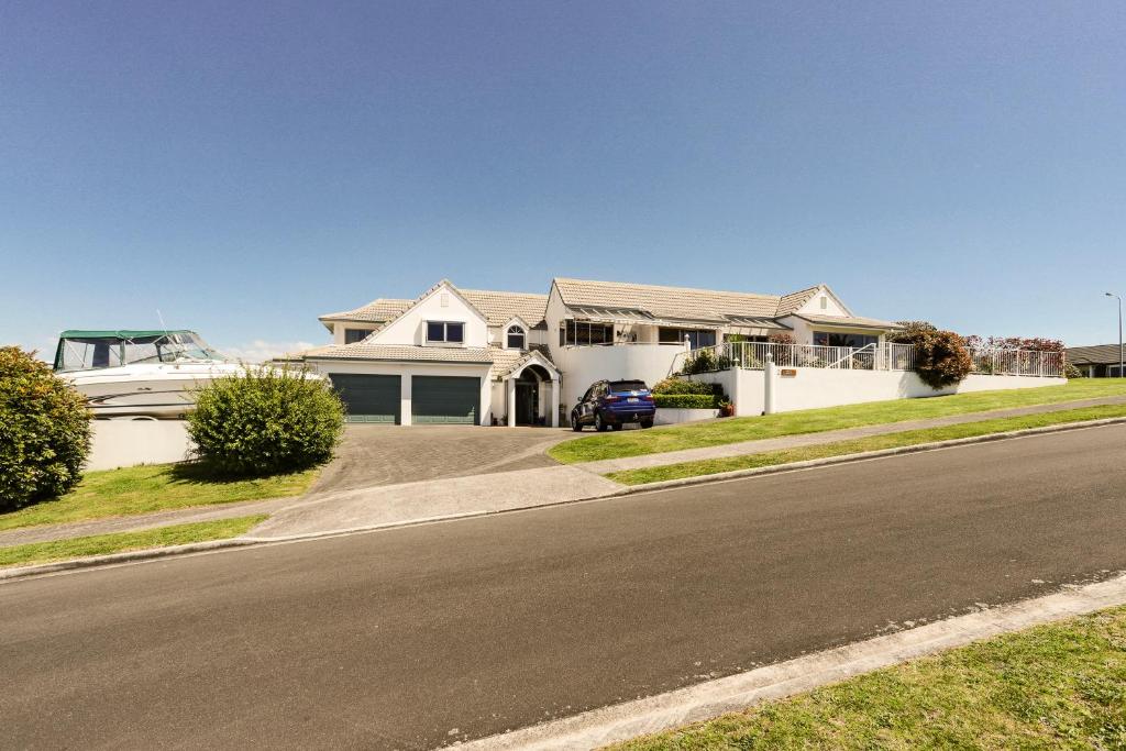 a house with a boat parked on the side of the road at Harbour Heights in Tauranga