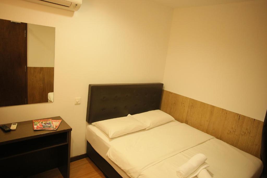 ムアルにあるN K Hotelの小さなベッドルーム(ベッド1台、ナイトスタンド付)