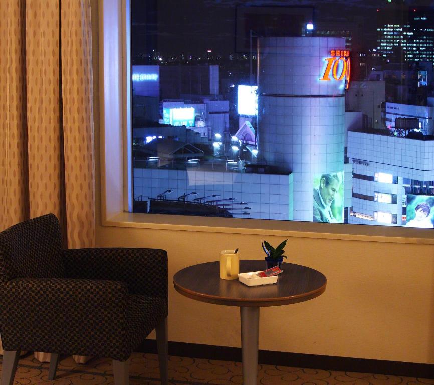 a table and a chair in a room with a window at Shibuya Excel Hotel Tokyu in Tokyo