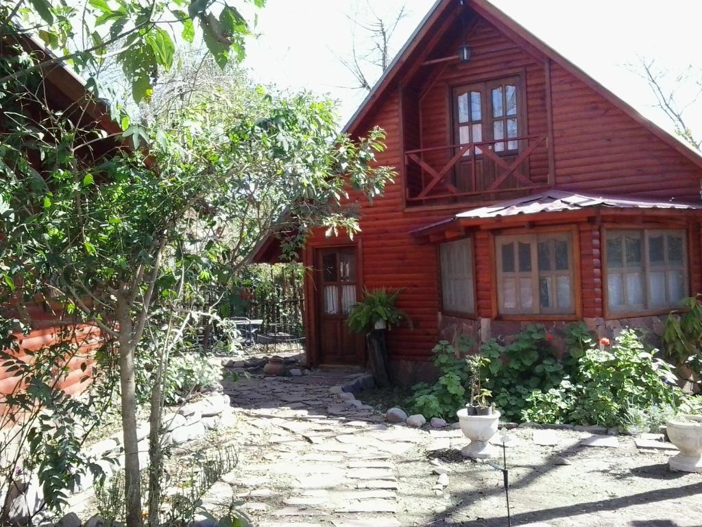 a wooden house with a stone pathway in front of it at Cabanas Inti-Wari Jujuy in El Ceibal