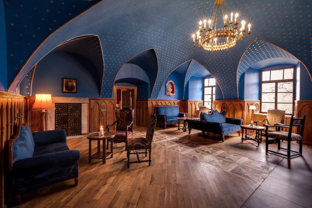 Spacious blue-arched salon with multiple velvet seats, wooden parquet floors and chandelier, calm refined atmosphere
