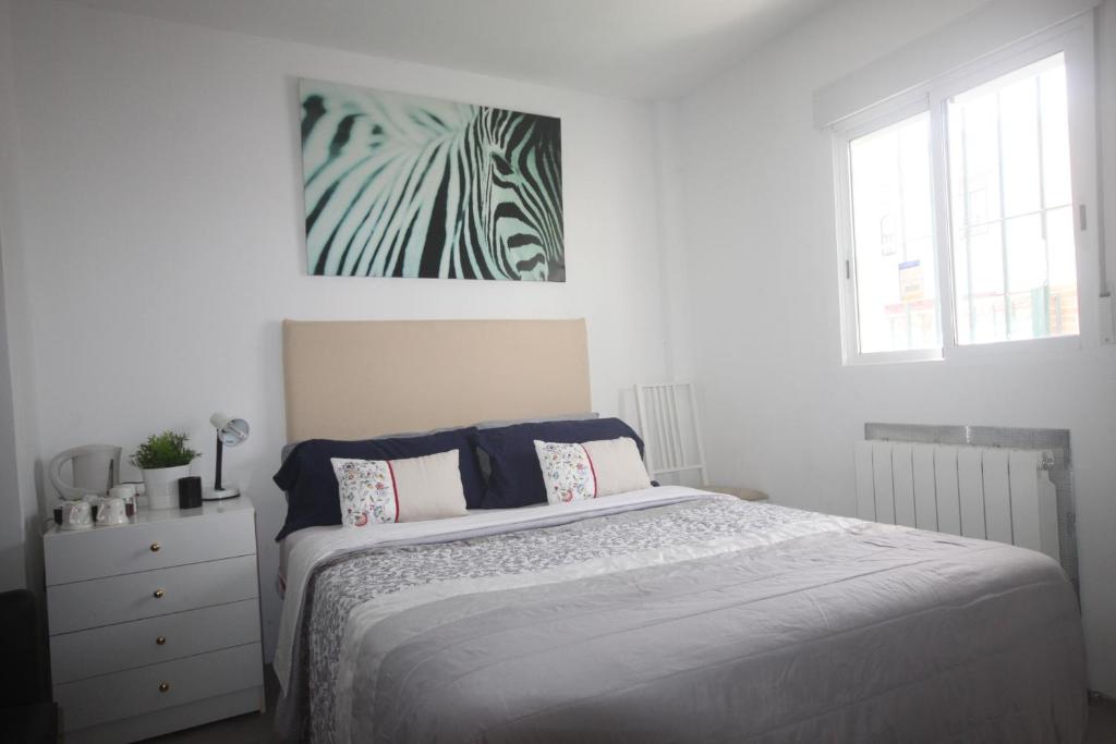 a bedroom with a bed and a painting on the wall at LITTLE PEACEFUL RETREAT Room with bath, Heating, Terrace, Free Wifi Fridge Easy parking in Nueva Andalucia