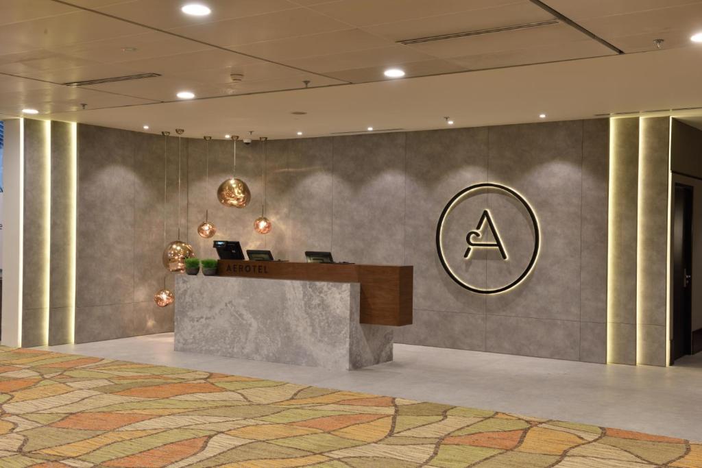 a lobby with a desk with two laptops on it at Aerotel Transit Hotel, Terminal 1 Airside in Singapore