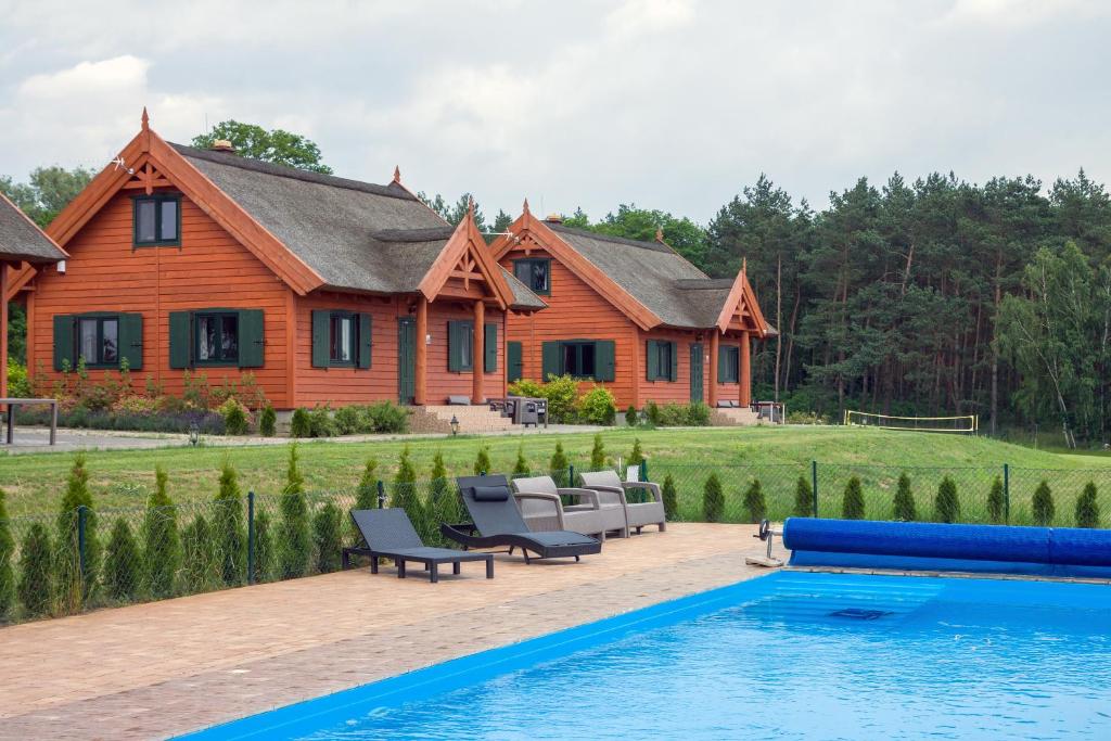 a house with a swimming pool in front of a house at Brzezina Resort - Wille in Żnin