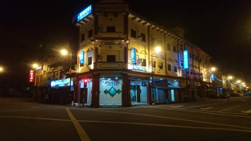 a building with blue lights on a street at night at Hotel Mill Road in Melaka