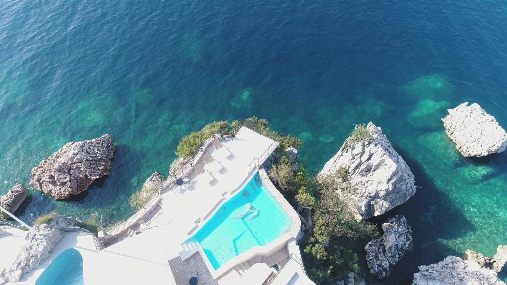 an aerial view of a villa and the ocean at Blanche Cliff Apartments in Sveti Stefan